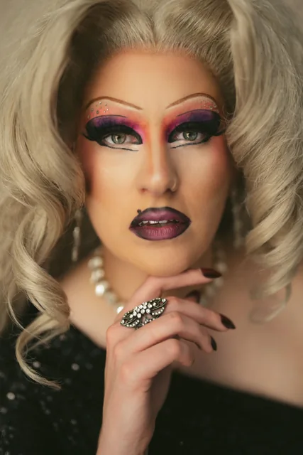 A close portrait with dramatic pink eye make-up and blonde hair.