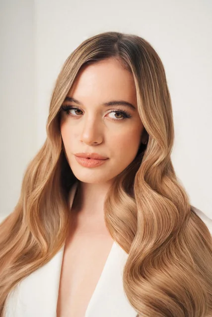 A softly lit beauty portrait showing long styled hair.