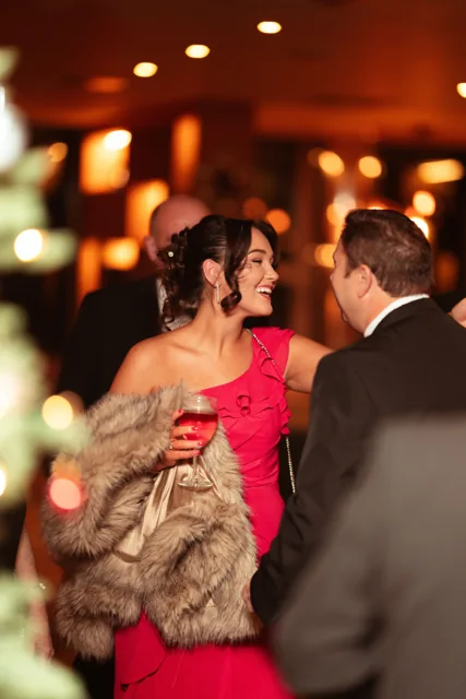 Guests in conversation at a warmly lit evening event.