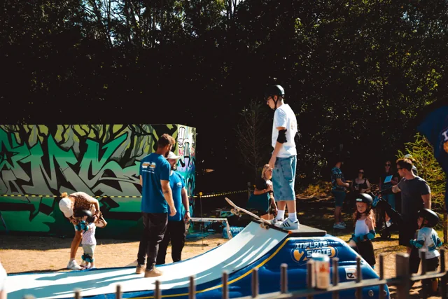 A skateboarder on a ramp in front of a festival crowd.