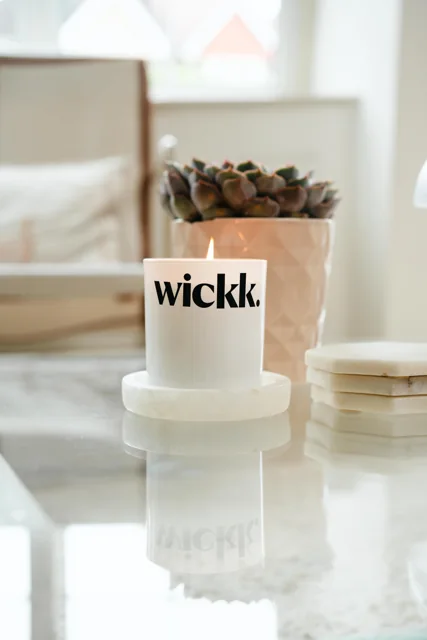 A Wickd candle styled in soft light.