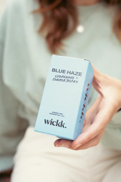 Hands holding a Wickd product package.